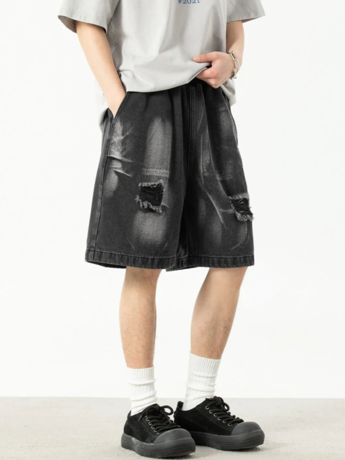 Model in men's plus size distressed denim shorts showing front and side view
