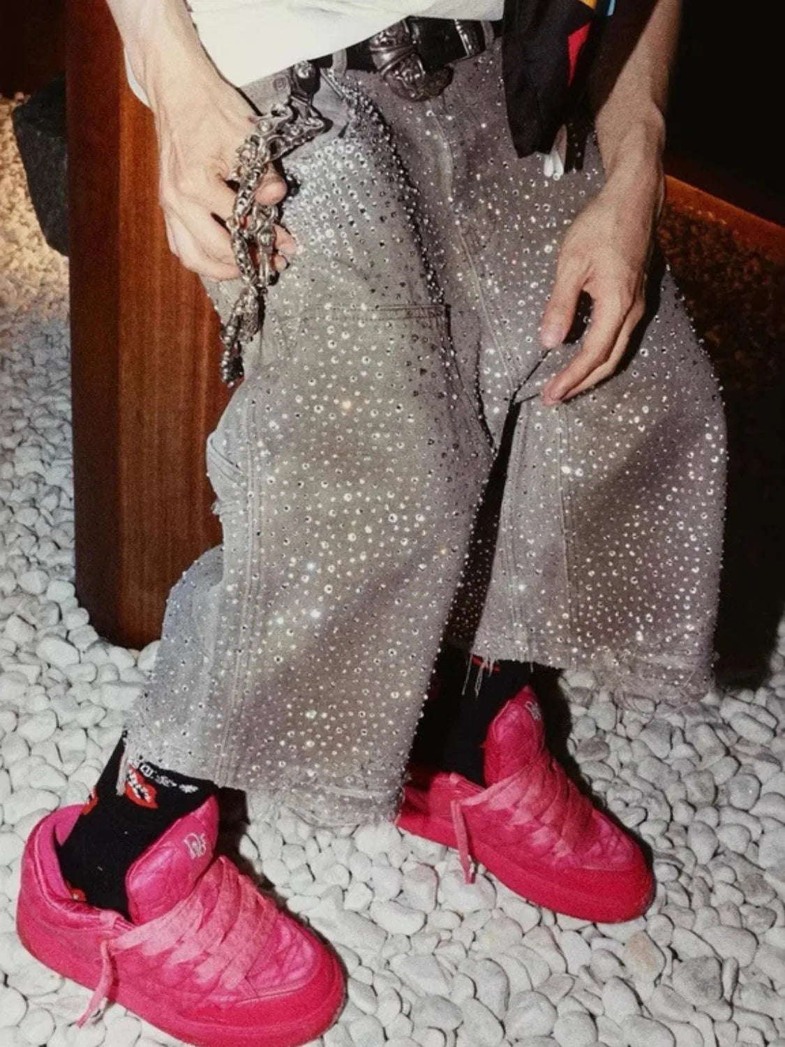 Model wearing fuchsia pink men's rhinestone shorts with pockets close up detail
