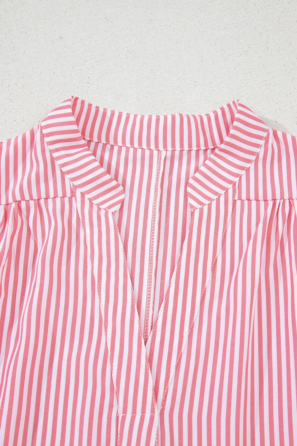 Close-up front view of stripe blouse notched neck collar detail
