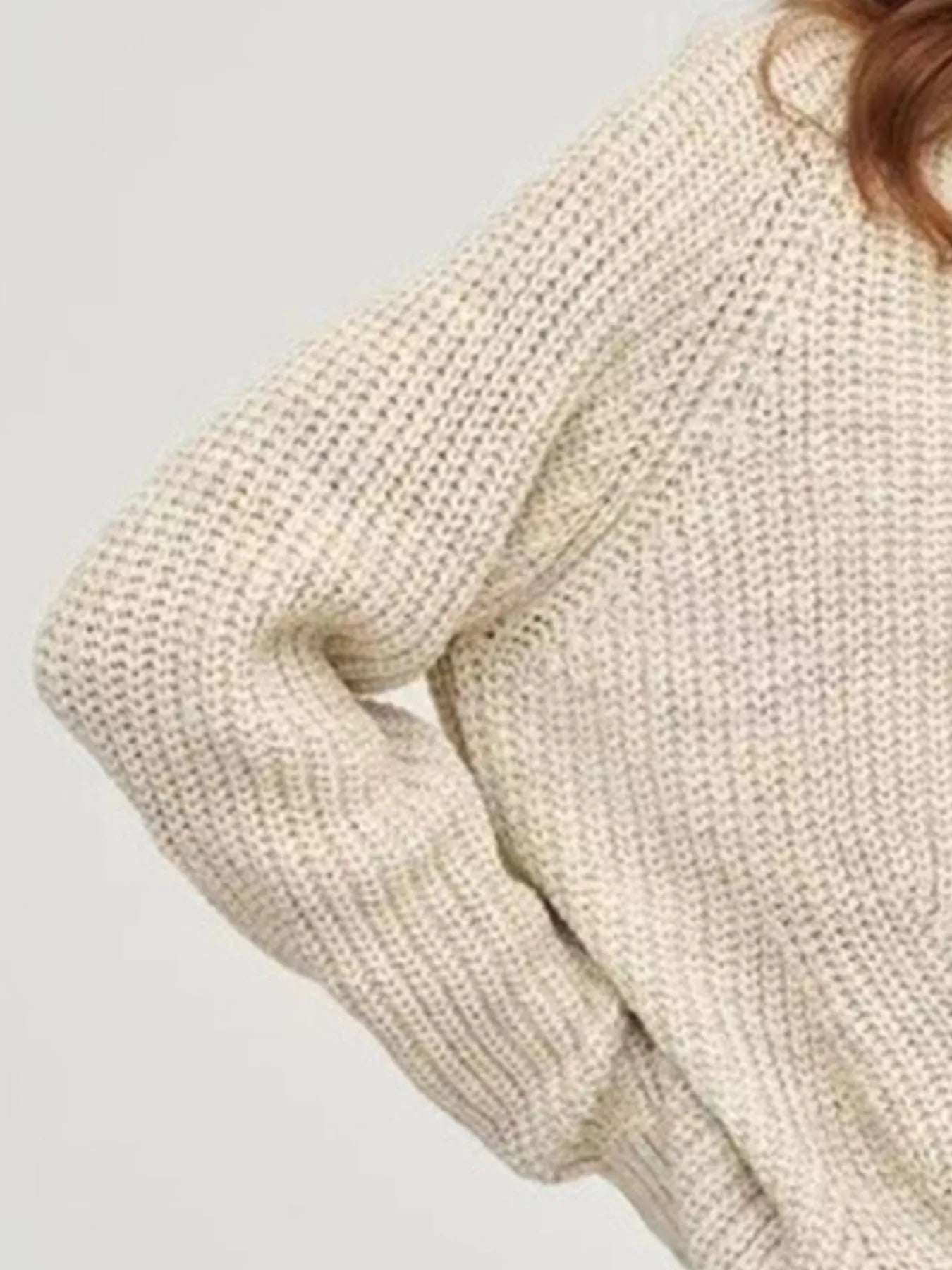 Beige oversized turtleneck long sleeve sweater sleeve close-up on model