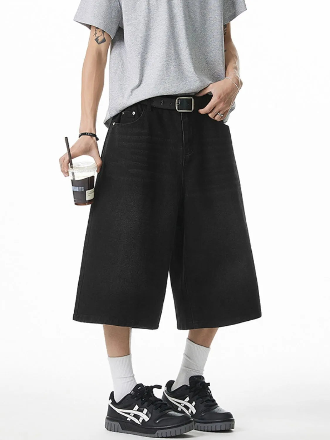 Model wearing men's plus size black denim pocketed shorts front view
