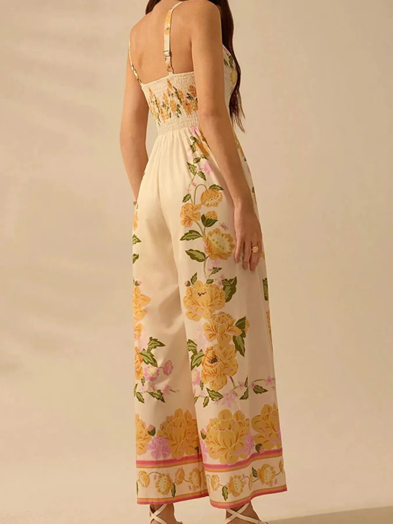 Model in floral print wide-leg V-neck cami jumpsuit showing back and side view
