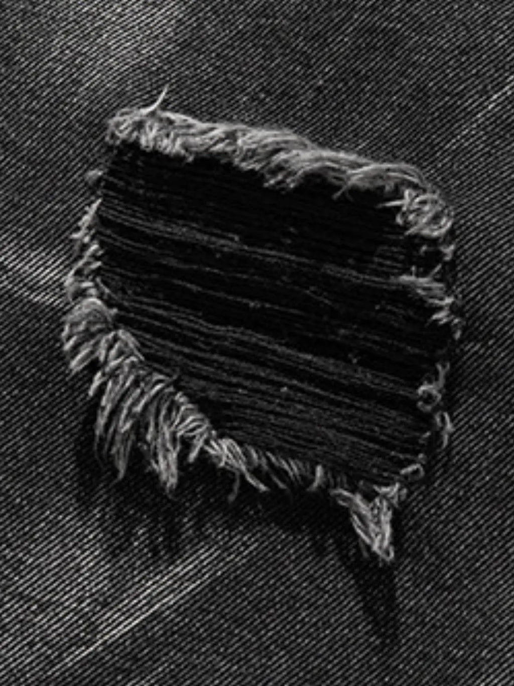Close up material detail of men's plus size distressed denim shorts
