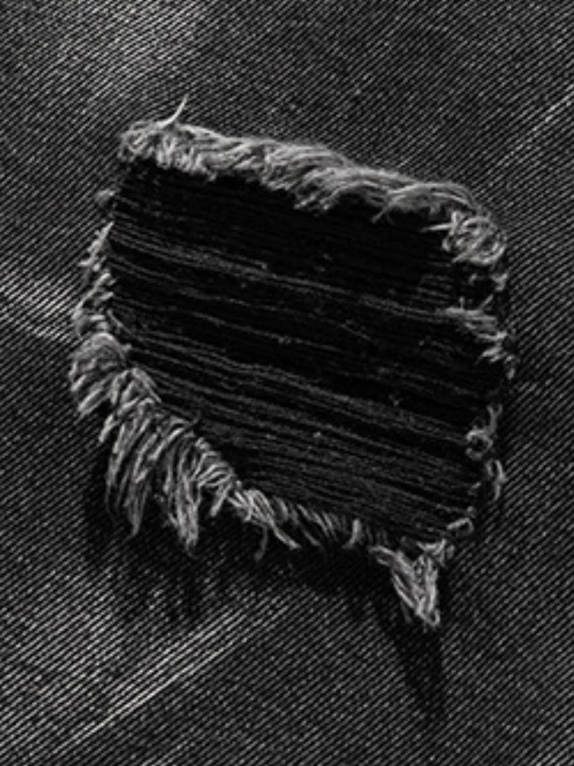 Close up material detail of men's plus size distressed denim shorts
