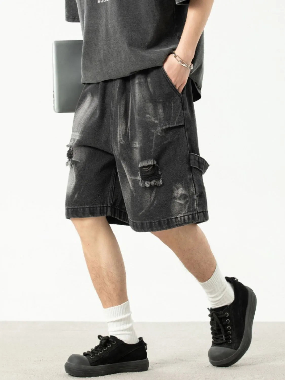 Model wearing men's plus size distressed denim shorts side view
